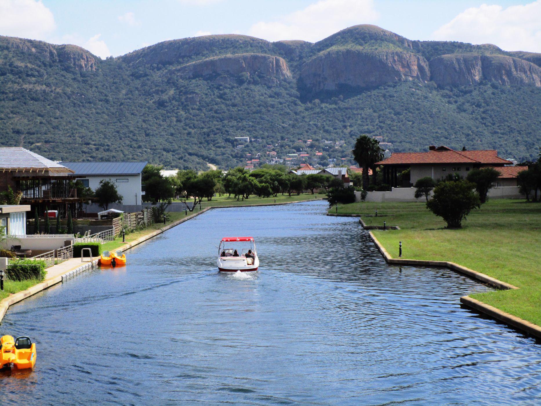 Boat In Canal Driving Towards Mountains